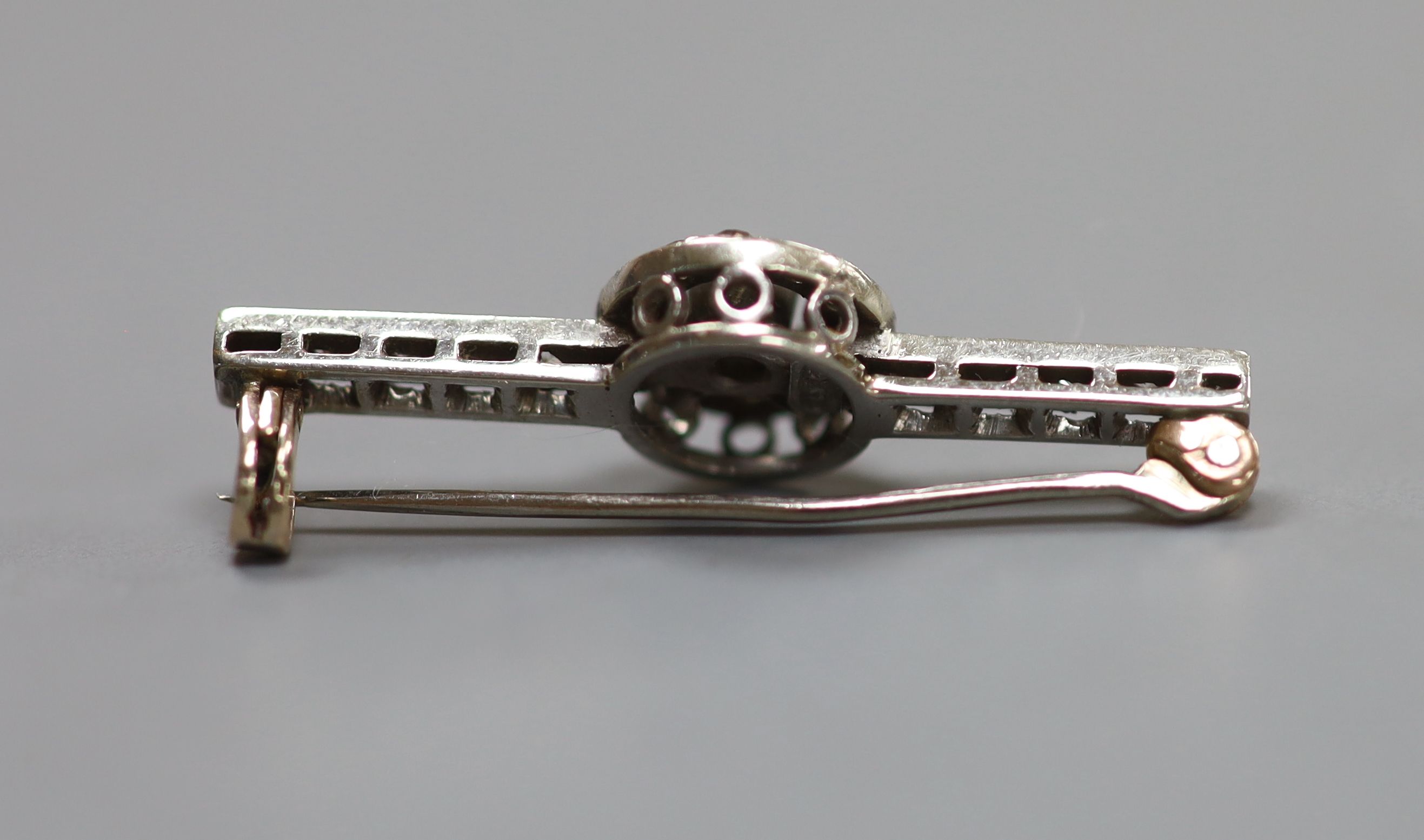 An early 20th century white metal (stamped 9ct) and diamond target cluster set bar brooch